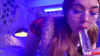 Dorm Hoe with glasses is sucking a transparent dildo.